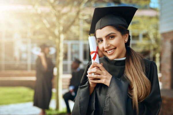 Portrait of a happy young woman holding a diploma on graduation day